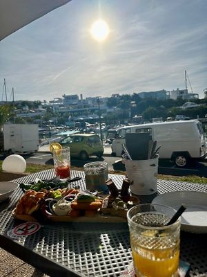 View over marina in the evening, mixed tapas for two persons, Virgin Mary and fresh orange juice at Boat House Bar in Mallorca
