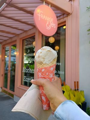 Cardamom apple pie seasonal flavor ice cream in a waffle cone, in front of the store. at Frankie & Jo's - University Village in Seattle