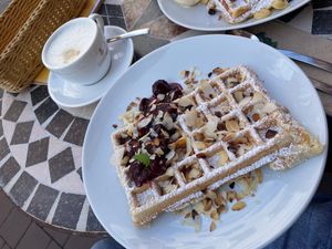 Waffle with marzipan, warm cherries and almonds and oat cappuccino  at Kleines Waffelhaus in Luebeck