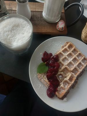 Vegan waffles with cherries and latte macchiato with oat milk at Kleines Waffelhaus in Luebeck