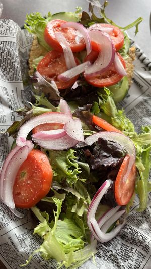 Open faced bagel sandwich : everything bagel topped with homemade red pepper hummus, spring mix, cucumber, tomato & onion.   at The Exchange in Colorado Springs