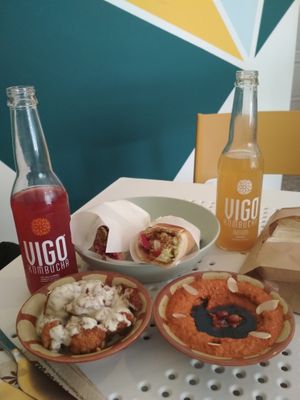 Fried cauliflower with taratour sauce (left), muhammara (right), a wrap (back) and something to drink, as served in August 2020. at Tahina Bite in Budapest