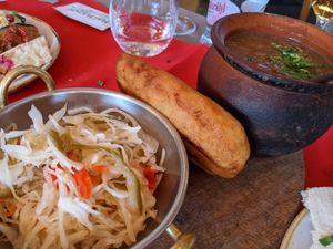 Pickles, corn bread, and bean stew. at Hachapuri in Budapest