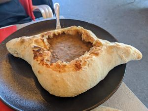 Traditional bread boat filled with bean stew. at Hachapuri in Budapest