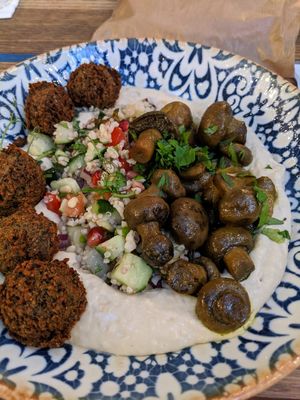 Hummus bowl topped with falafel balls, tabouli and Yemeni-style mushrooms.  at Mazel Tov in Budapest