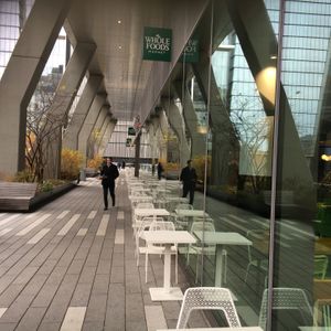 Outdoor seating and one of the entrances to the Whole Foods food court. at Jajaja Mexicana - Hudson Yards in New York City