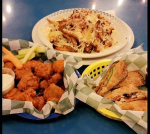 Tiger wings, dico fries, & avocado rolls. at The Green Pig Pub in Salt Lake City