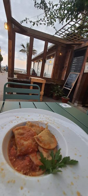 Raviolis artesanos con bechamel y espinacas, con salsa de tomate casera y levadura nutricional at Brio in Tarifa