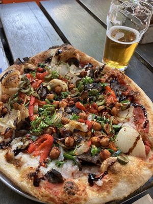 Nom nom vegan pizza and a beer  at Drake's Dealership in Oakland