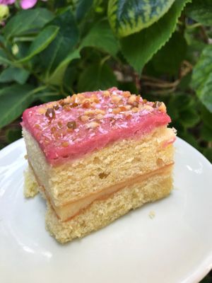 Vegan cake: fluffy lychee/raspberry cake, decorated with pistachio, almond, coconut. at Patisserie de Bijenkorf in Amsterdam