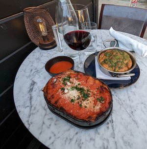 Impossible lasagna & garlic knots paired w/ a glass of Barbera D'Asti. at BAIA in San Francisco
