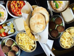 Our famous Egyptian breakfast consisting of Falafel, Scrambled Eggs(option to switch it for falafel for vegans), tahini sauce, pickles, cheese and tomato and Foul at Time Out Cafe in Glasgow
