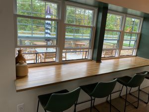 Indoor seating by a window looking into outdoor seating at The InkWell in Littleton
