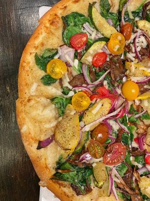 Roasted Veggie Pizza - oyster mushrooms, zucchini, red onion, tomato, spinach, creamy garlic sauce, vegan cheese at Down 2 Earth Plant Based Cuisine in Las Vegas