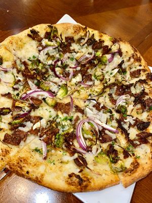 Bacon n' Brussel Pizza - brussel sprouts, smoked tempeh, red onion, creamy garlic sauce, vegan cheese at Down 2 Earth Plant Based Cuisine in Las Vegas