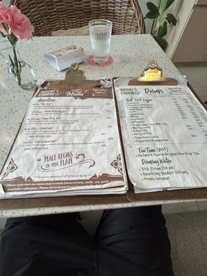 Cute menu and lemon water in background  at Nature's Charm in Bangkok