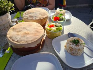Vegan vegetable stew baked served in a stone bowl with the bread baked on top of the bowl, rice and a small mixed salad at Seran in Bad Harzburg
