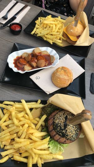 black and cheddar burger with curry-vurst as side  at Seepintli in Sutz-lattrigen