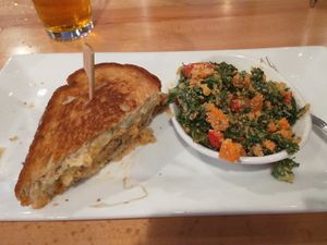 A half eaten Reuben with a side peanut kale salad. at Seva - Ann Arbor in Ann Arbor