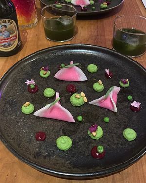PRINZESSIN AUF DER ERBSE: Kohlrabi-Randen-Triangoli, Erbsenpüree, Preiselbeergel, Pinienkerne, Estragon. (Juice: Peterli-Shrub)  at ANOAH in Zurich
