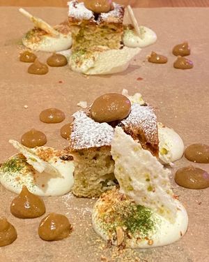 DIRECTLY ON THE TABLE: Pistazien-Apfel-Bisquit, gebrannte Mandel, Meringues Bratapfel, Limetten-Crème. (Juice: Apfel-Thymian-Most)  at ANOAH in Zurich