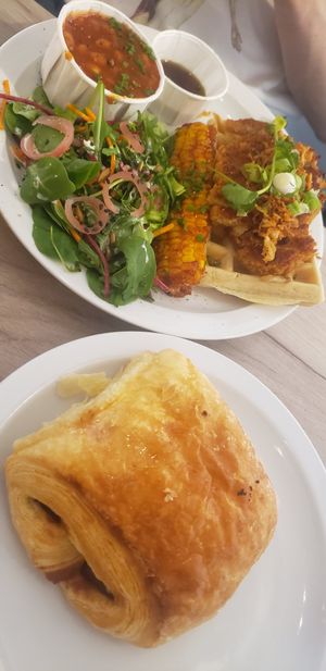 Chicken waffles, corn, cinnamon tomato beans and pain au chocolat at Lucifer Lives in Brussels