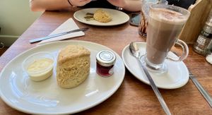 Vegan scone, cream, jam and hot chocolate in foreground.  at The Greenwood Tree in Lyndhurst