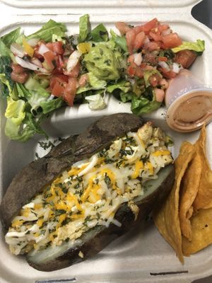 Papa asada rellena de “pollo” y “queso” acompañado de ensalada y chips at La Zanahoria in Bayamon