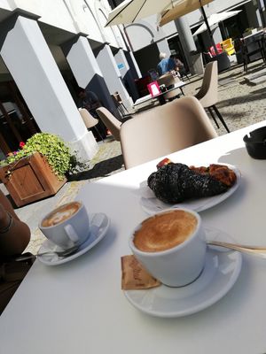 Cappuccino con latte di soia, brioches al carbone nero farcita sul momento con marmellata di frutti di bosco at Havana Café in Bardonecchia