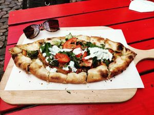 Pide Amara Vegan - Crispy baked yeast flatbread with veggies, soy döner 'meat' pieces, vegan cheese, vegan yoghurt and dill sauce and sunglasses as a scale of reference. It's mass at Amara in Freiburg