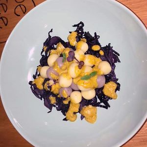 Two-tone potato gnocchi with purple cabbage and yellow pepper cream at Be Free in Olbia