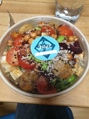 Quinoa, salad, tofu, falafel, crunchy chickpeas, tomatos, edamame, beetroot, and seed topping with sesame-ginger dressing at Jawz The Bowl Company in Munich