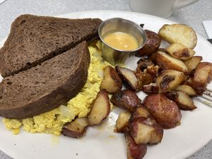 Tofu Scramble with breakfast potatoes, house creamy cheese and dark rye toast  at Donut Villa Diner in Malden