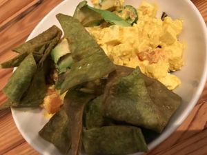 AGV Scramble with tofu, peppers, onions, tomato, avocado, almond milk, fried kale leaves and crispy spinach chips. at Cafe Nola in Frederick
