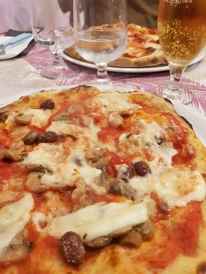 Pizza rossa con mozzarella di riso, olive taggiasche e funghi at Pizzaria Peperetta Dispetusa in Imperia
