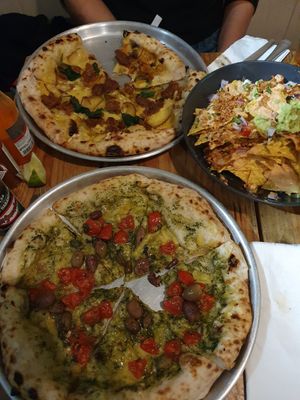 Nachos, pesto and pomodoro pizza, potato and sausage pizza at Plant Base in Lisbon