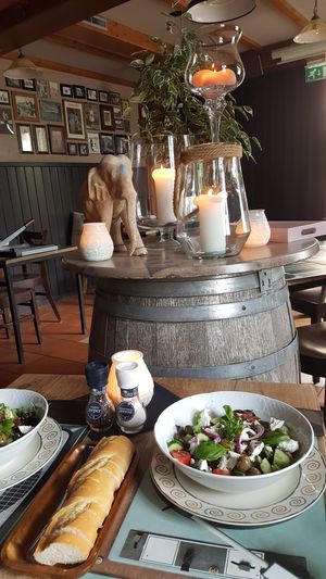 Our Greek salad is standard Vegetarian. But we can make it Vegan. No problem. The background is our small and cosy indoor restaurant. at Eetcafé Driewegen in Terneuzen