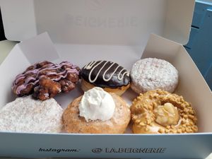 Blueberry fritter, Crème St-Denis, 2×jam la confiture (jelly powdered donuts), Crème brûlée?, Á en tomber dans les pommes (apple caramel with nuts) at La Beignerie in Montreal