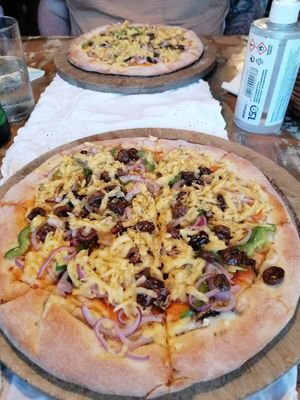 Vegan pizza with onions, peppers, olives and cheese at Raeti in Crete