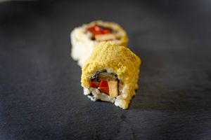 Uramaki Escalivat: Uramaki de Arroz integral con pimiento rojo y berenjena horneados con ajo + tofu ahumado+ topping de olivada verde  at Veganashi - Gluten Free Sushi in Barcelona