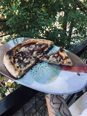Cebollas moradas caramelizadas al curry en masa al estilo napolitano at Nómada in Buenos Aires