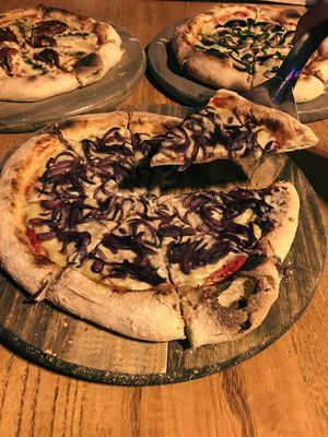 Cebollas moradas caramelizadas al curry en masa al estilo napolitano at Nómada in Buenos Aires