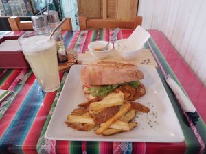 Sándwich Vital:  tofu apanado, cebolla caramelizada, mix de hojas verdes , queso vegano, tomate, babaganush con papas rusticas at Estrella Negra in San Pedro De Atacama