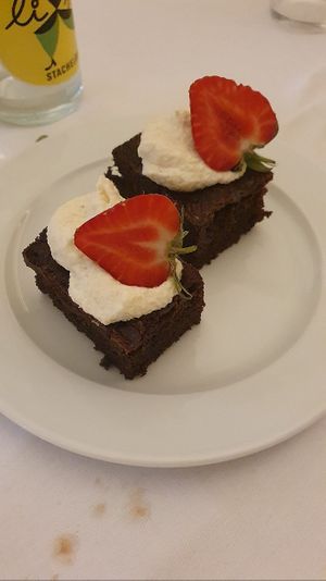 Chocolate brownie with strawberries and coconut cream at Mala in Leipzig