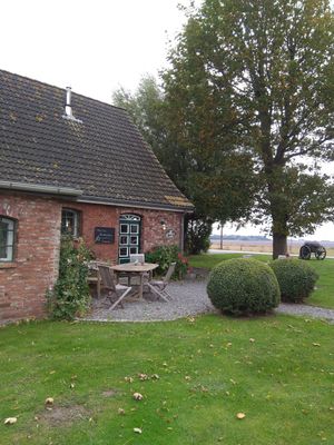 Außenansicht (hinterm Haus ist ein großer Bereich mit Strandkörben zum Sitzen) at Koog Café in Wesselburenerkoog