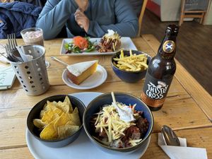 All vegan: baked potato with chili, rice with chili, tortilla chips, lemon icing cake, hot chocolate with marshmallows, fries and a Scottish cider.   at Ness Deli in Drumnadrochit