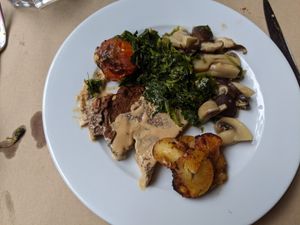 Seitan with gravy, roasted tomato, sauteed greens, mushrooms, and potatoes at GAO in Matosinhos