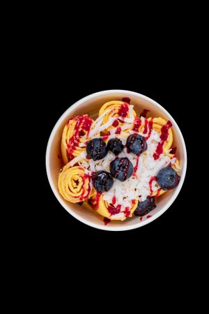 Vegan mango ice cream with fresh strawberries topped with coconut, fresh blueberries, and raspberry drizzle.  at Where's The Scoop? in Alpharetta