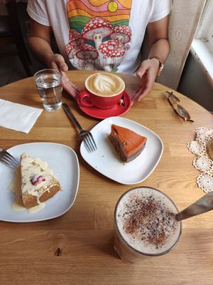 Strawberry-rhubarb cake (left), chocolate-orange raw cake (right), cappuccino & chai latte with oat milk at Kahvila Oskari in Lahti