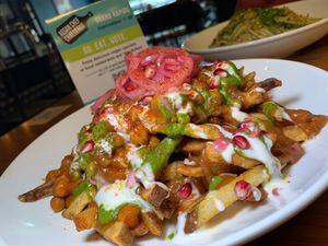 Samosa Chaat Poutine: Chickpea Chutney, Peas, Pomegranate, Pickled Red Onions, Cilantro/Mint Chimichurri, Vegan Crema, Tamarind/Date Sauce, House-Cut Fries (Grand Rapids Vegan Chef Challenge 9/25) at The Friesian in Grand Rapids